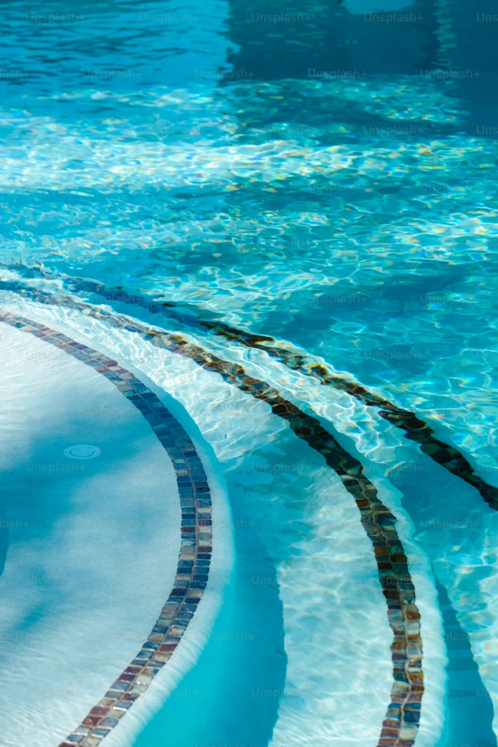 Dettaglio elegante di una scalinata per piscina con acqua limpida, simbolo di qualità e stile offerti da ChimicaBlu.