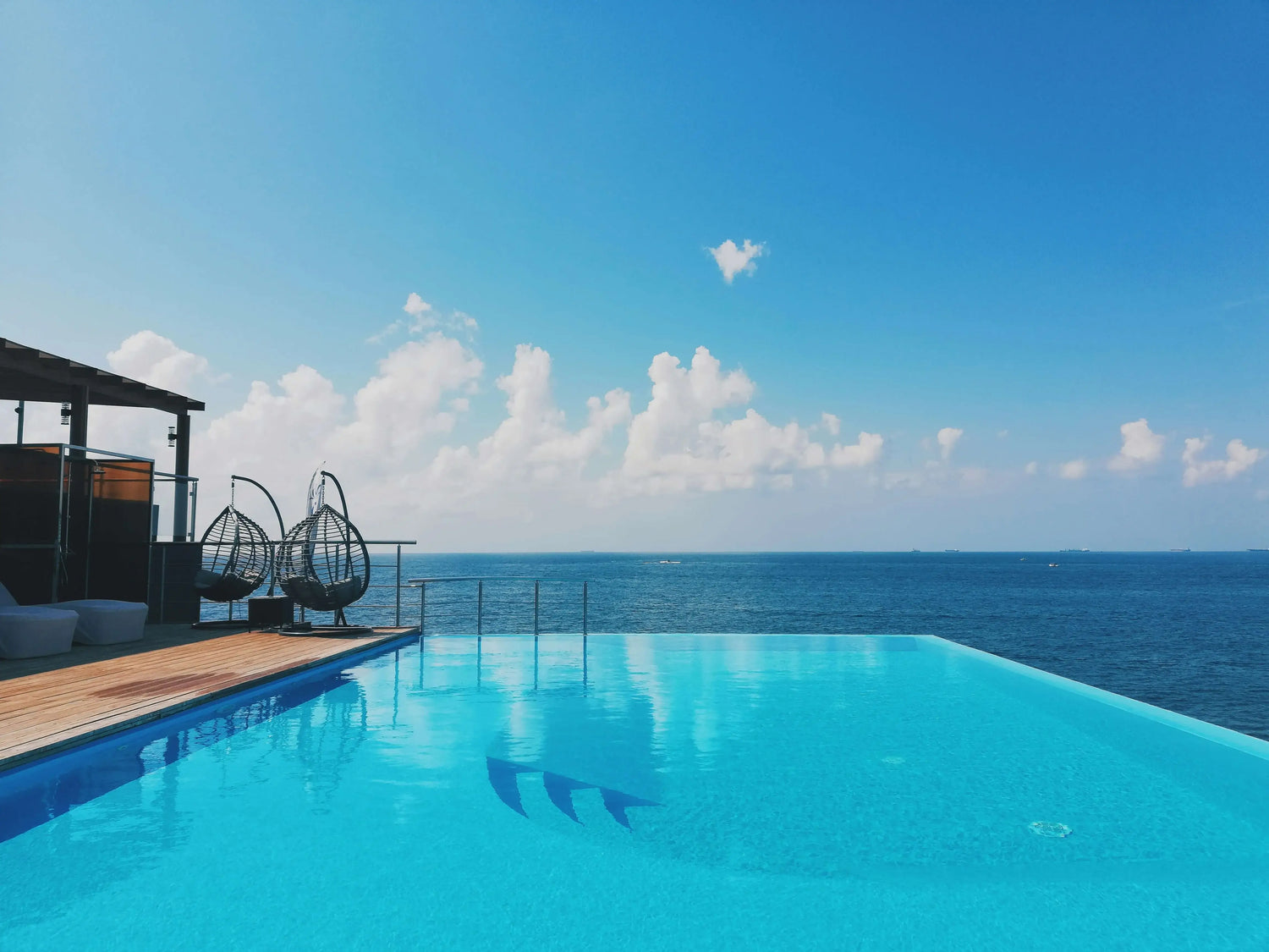 Piscina a sfioro elegante con vista panoramica sull’oceano, esempio di lusso e benessere firmato ChimicaBlu per spazi esclusivi sul mare.